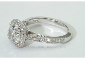 Round brilliant cut diamond set in a vintage inspired halo on a bead set mill grain cathedral band.