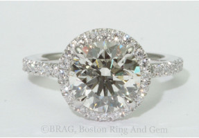 Round brilliant cut diamond set in round halo on a none cathedral fishtail set band.