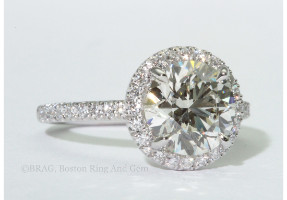 Round brilliant cut diamond set in round halo on a none cathedral fishtail set band.