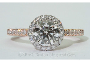 Round brilliant cut diamond set in a two tone platinum and rose gold round halo on a none cathedral French cut set band.