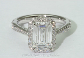 Emerald cut diamond set in a fishtail set tapered cathedral halo.