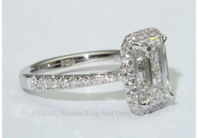 Emerald cut diamond set in a fishtail set tapered cathedral halo. 