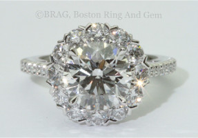 Round brilliant cut diamond set in cupe style halo on a thing French cut set cathedral band.