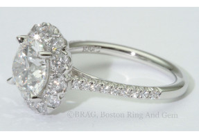 Round brilliant cut diamond set in cupe style halo on a thing French cut set cathedral band.