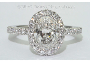 Oval brilliant cut diamond set in oval halo on a none cathedral French cut set band.