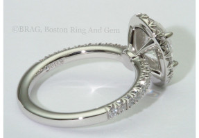 Oval brilliant cut diamond set in oval halo on a none cathedral French cut set band.