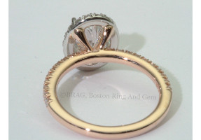Oval brilliant cut diamond set in oval halo on a none cathedral French cut set rose gold band.