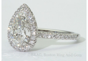 Pear cut diamond set in oval halo on a none cathedral French cut set band.